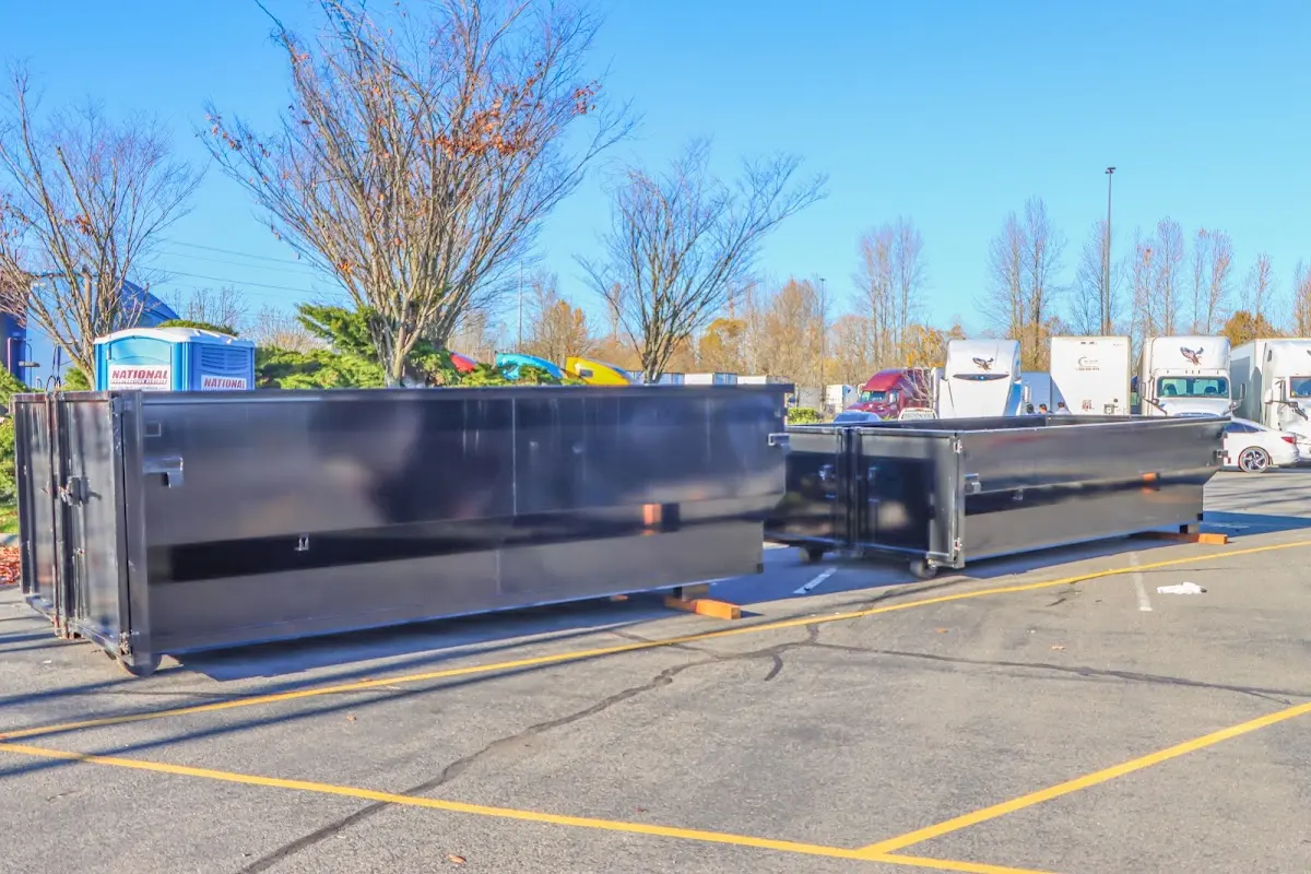 Professional dumpster rental service with roll-off container on residential driveway in Forest Hill